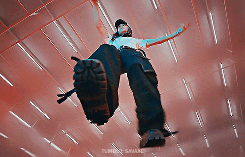 A Person In A White Shirt And Black Pants Is Standing In A Room With A Red Ceiling GIF