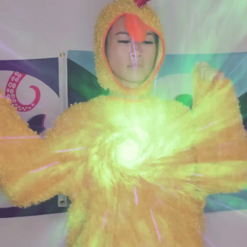 A Person In A Yellow Chicken Costume Is Holding A Green Light GIF