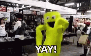 A Person In A Yellow Costume Is Standing In A Crowded Room And Saying `` Yay ! '' GIF