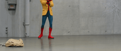 A Person In A Yellow Jacket Stands In Front Of A Wall With Snowflakes Drawn On It GIF