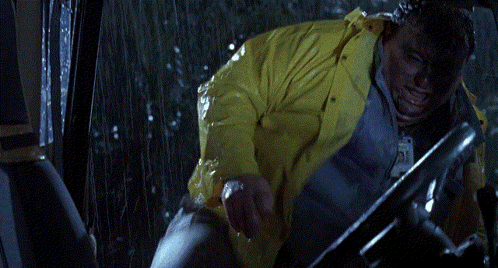 a person in a yellow raincoat is driving a vehicle