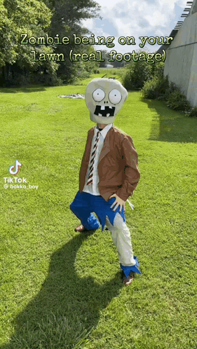 A Person In A Zombie Costume Is Standing On A Lush Green Lawn GIF