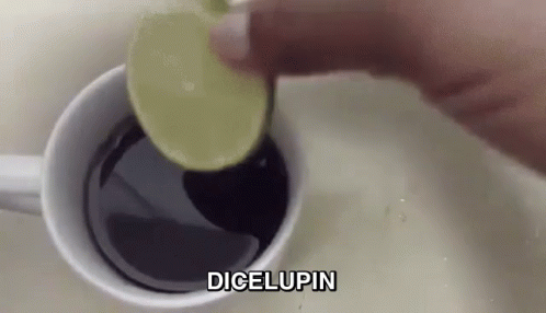 A Person Is Adding A Slice Of Lime Into A Cup Of Coffee . GIF