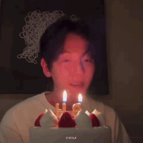 A Person Is Blowing Out Candles On A Birthday Cake . GIF