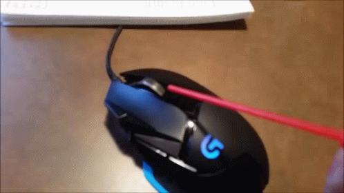A Person Is Cleaning A Logitech Mouse With A Red Brush GIF