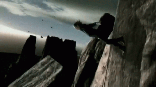 A Person Is Climbing Up A Rocky Cliff GIF