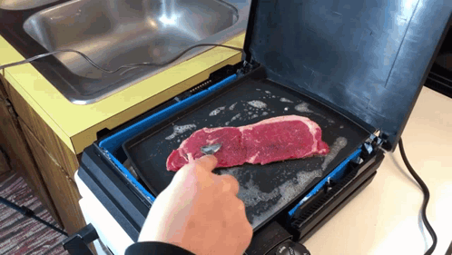 A Person Is Cooking A Steak On A Griddle In A Kitchen GIF