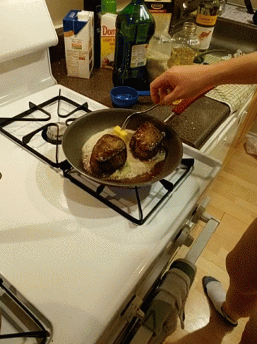 A Person Is Cooking On A Stove Next To A Box Of Don 'S GIF