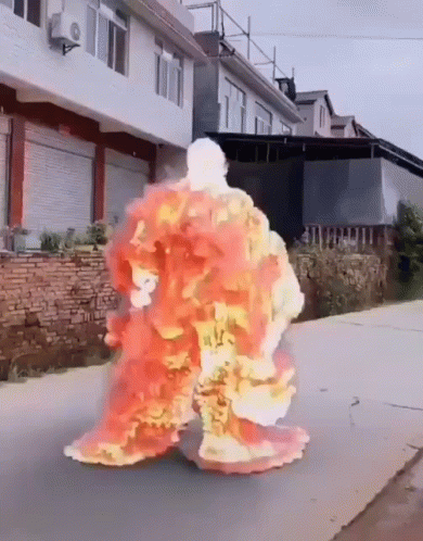 A Person Is Covered In Flames While Walking Down The Street GIF