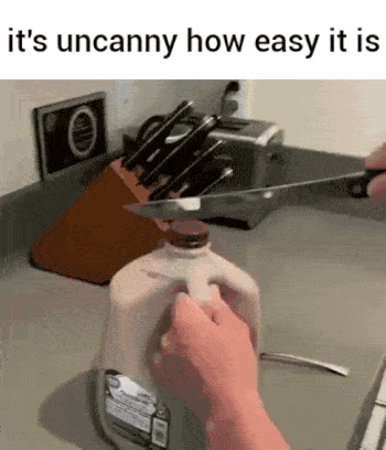 A Person Is Cutting A Gallon Of Milk With A Knife In A Kitchen . GIF