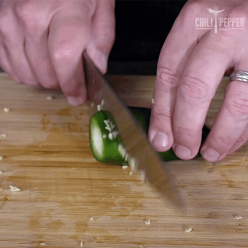 A Person Is Cutting A Jalapeno Pepper On A Wooden Cutting Board With Chili Pepper Written On The Bottom GIF