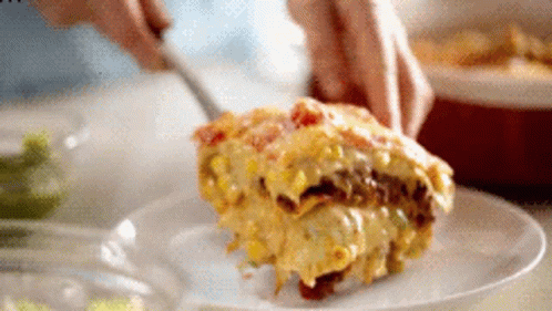 A Person Is Cutting A Piece Of Food On A Plate GIF