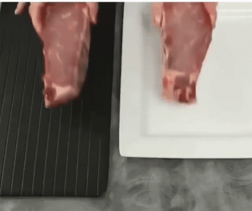 A Person Is Cutting A Piece Of Meat On A Black Cutting Board . GIF