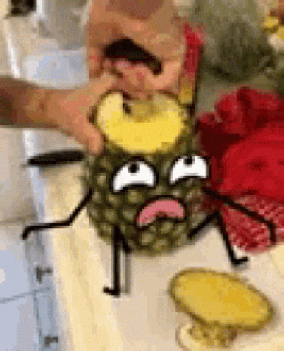 A Person Is Cutting A Pineapple With A Cartoon Face On It On A Table . GIF