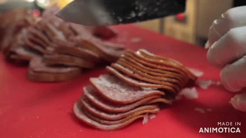 A Person Is Cutting Bacon On A Red Cutting Board With The Words Made In Animatica On The Bottom GIF