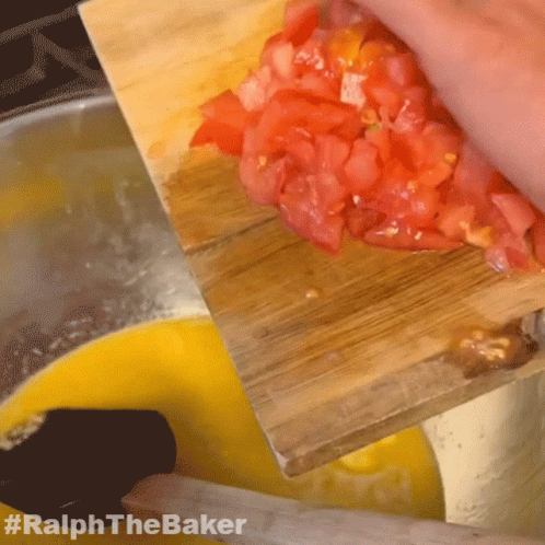 A Person Is Cutting Up Tomatoes On A Wooden Cutting Board With #Ralphthebaker Written On The Bottom GIF