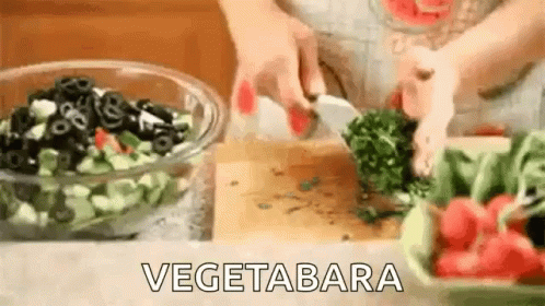 A Person Is Cutting Vegetables On A Cutting Board . GIF