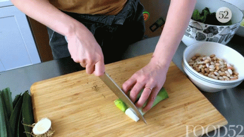 A Person Is Cutting Vegetables On A Wooden Cutting Board With The Number 52 In The Corner GIF