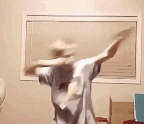 A Person Is Dancing In A Room In Front Of A Window . GIF