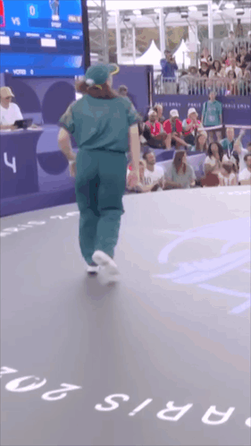 A Person Is Dancing In Front Of A Crowd And A Sign That Says Paris 20 GIF