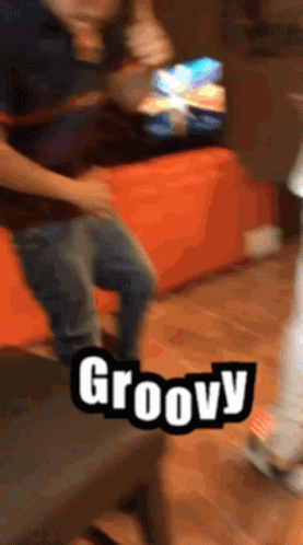 A Person Is Dancing In Front Of A Sign That Says Groovy On It GIF