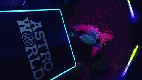 A Person Is Dancing On A Stage In Front Of A Sign That Says Astro World . GIF