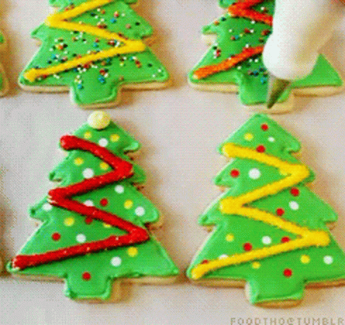 A Person Is Decorating Christmas Trees With Green Frosting GIF