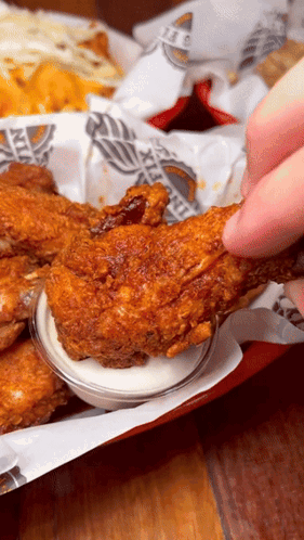 A Person Is Dipping A Piece Of Fried Chicken In Ranch Sauce GIF