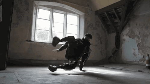 A Person Is Doing A Trick In A Dark Room With A Window GIF