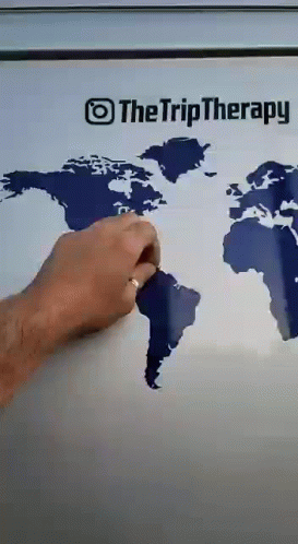 A Person Is Drawing A Map Of The World On A Refrigerator Door GIF