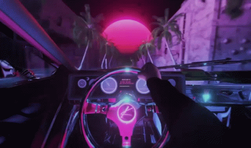 A Person Is Driving A Car With A Steering Wheel That Has A K On It GIF