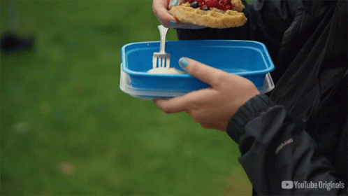 A Person Is Eating A Slice Of Pizza From A Blue Container With A Fork In It GIF