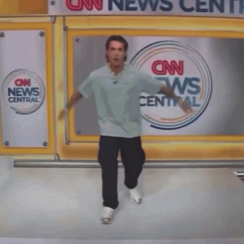 A Person Is Falling In Front Of A Cnn News Central Sign GIF