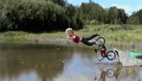 A Person Is Falling Into A Lake With A Bicycle GIF