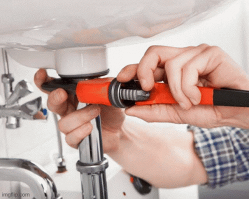 A Person Is Fixing A Pipe Under A Sink Using A Wrench GIF