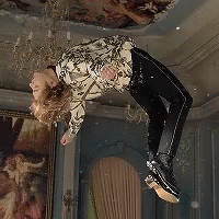 A Person Is Flying Through The Air In A Room With A Painting On The Wall . GIF