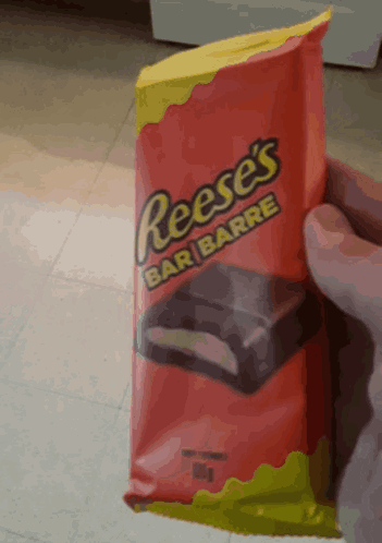 a person is holding a bag of reese 's bar