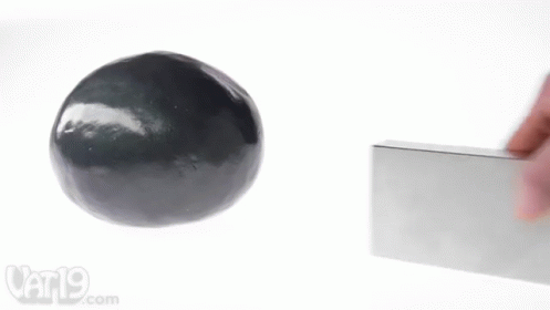 A Person Is Holding A Block Next To A Black Ball And A Vat19.com Logo GIF