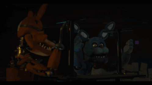 a person is holding a blue object in their hand in a dark room