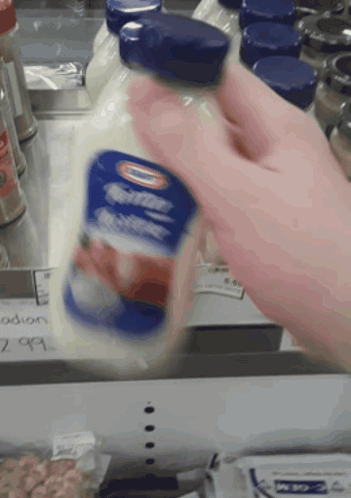 A Person Is Holding A Bottle Of Buttermilk GIF