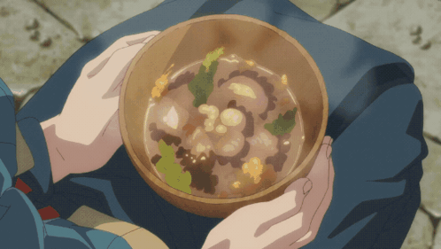 A Person Is Holding A Bowl Of Soup With Vegetables GIF