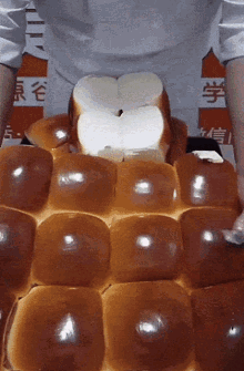 A Person Is Holding A Bunch Of Bread In Front Of A Sign That Says ' Chinese ' On It GIF