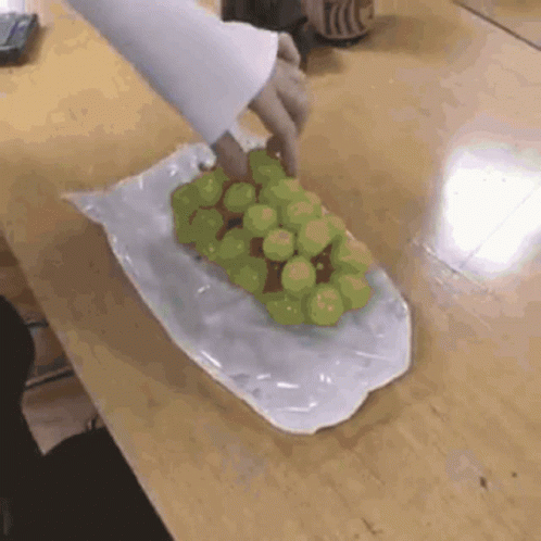 A Person Is Holding A Bunch Of Grapes In A Plastic Bag GIF
