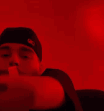 A Person Is Holding A Bunch Of Money In Their Hands In A Red Light . GIF