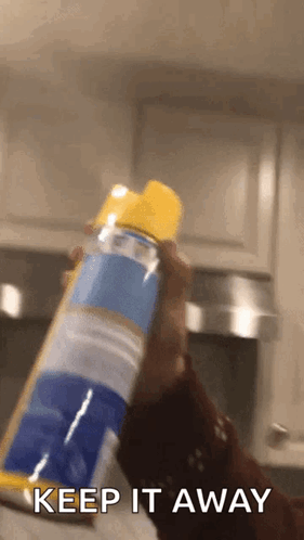A Person Is Holding A Can Of Air Freshener In Their Hand And Says Keep It Away . GIF