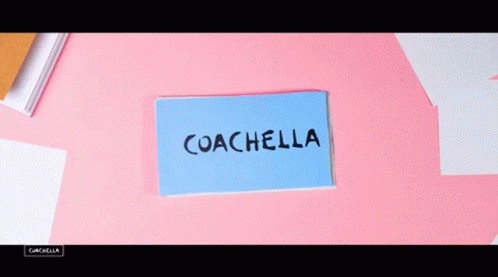 A Person Is Holding A Card That Says Coachella On It GIF