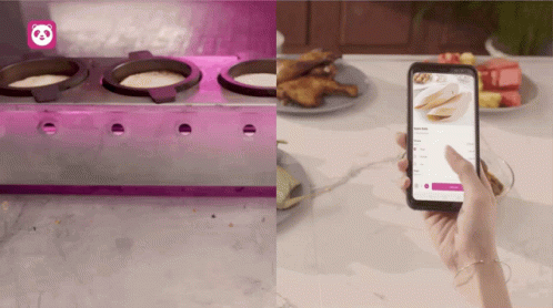A Person Is Holding A Cell Phone In Front Of A Stove And A Plate Of Food GIF