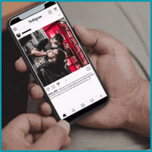 A Person Is Holding A Cell Phone With A Picture Of A Man Getting A Haircut On It GIF