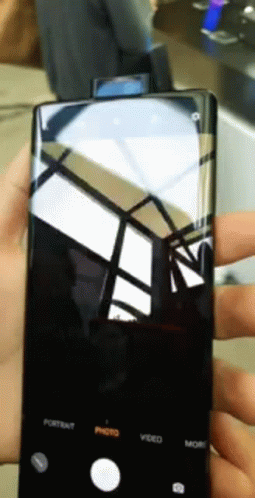 A Person Is Holding A Cell Phone With The Portrait Photo Video And More Buttons On It GIF
