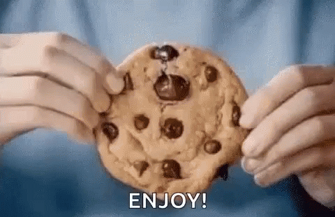A Person Is Holding A Chocolate Chip Cookie In Their Hands And Says `` Enjoy '' . GIF